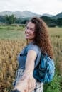 Smiling female traveler holding hand of boyfriend and in nature in daytime