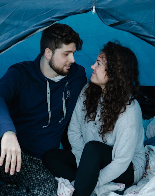 Loving young couple relaxing in tent during camping