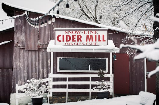 Winter scene of Snow-Line Cider Mill in Oak Glen, California, covered in snow with a rustic charm.