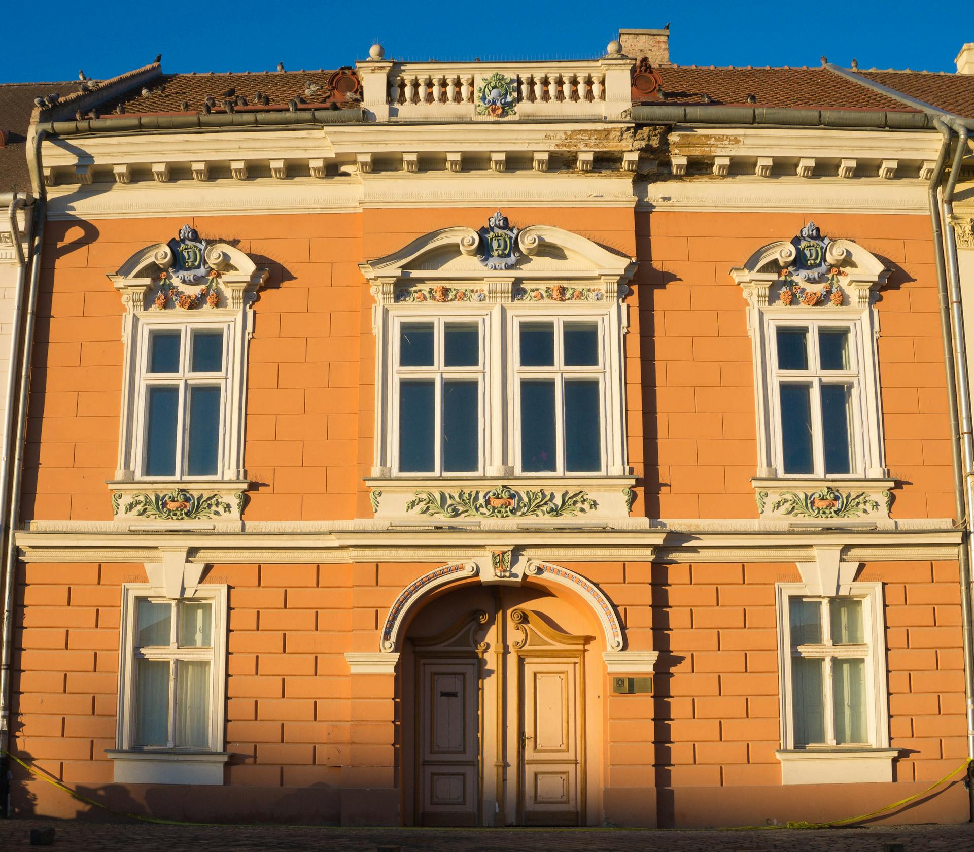 A beautiful historic building facade with intricate decorations and vibrant colors captured in daylight.