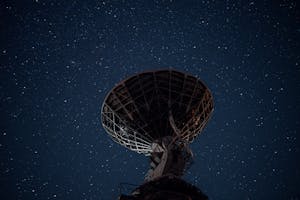 Radio telescope under bright starry sky