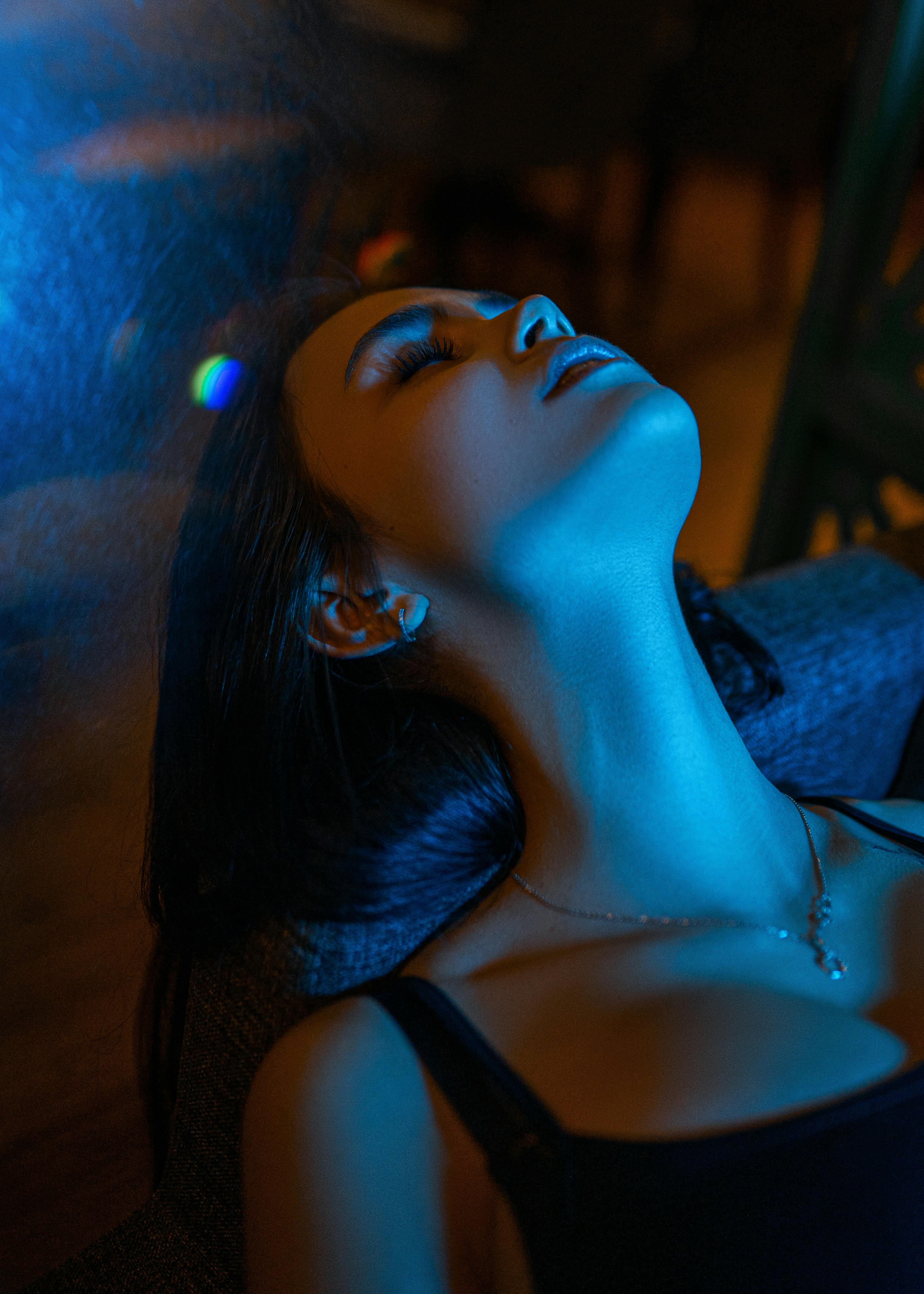 Serene woman with eyes closed in soft hypnotic relaxation, face calm and surrendered under gentle light
