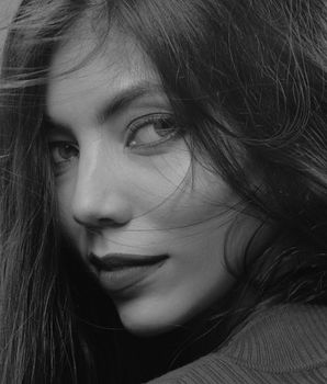 Elegant black-and-white portrait of a woman with flowing hair, adding a dramatic and artistic touch.
