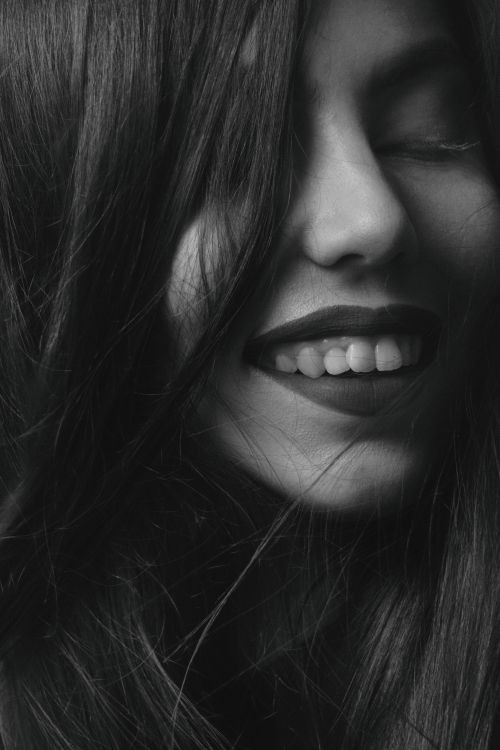 Free Beautiful black and white close-up portrait of a smiling woman with long hair. Stock Photo