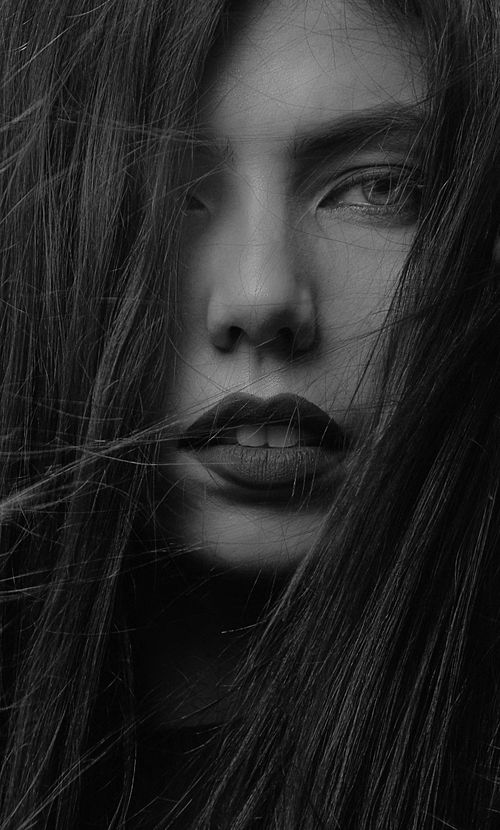 Free Close-up black and white portrait of a woman with expressive features and messy hair. Stock Photo