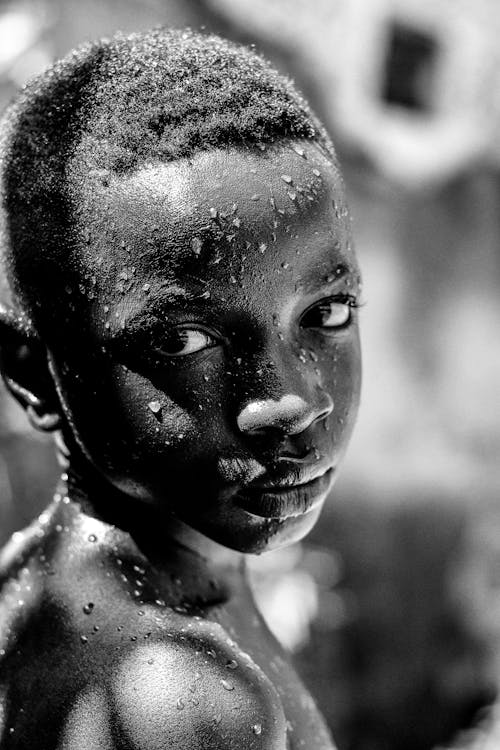 Grayscale Photo of a Boy With Water Drops on Face