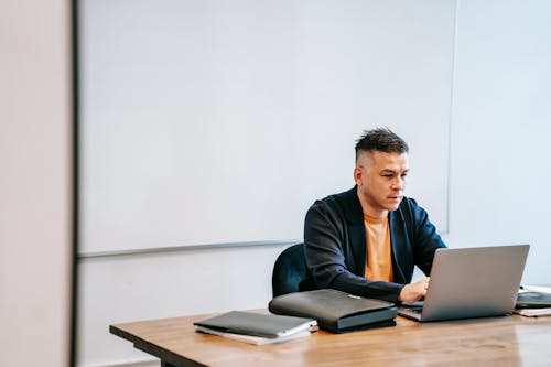 A Man Typing on a Laptop