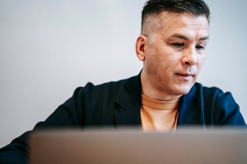 Close-Up Photo Of Man In Front Of His Laptop