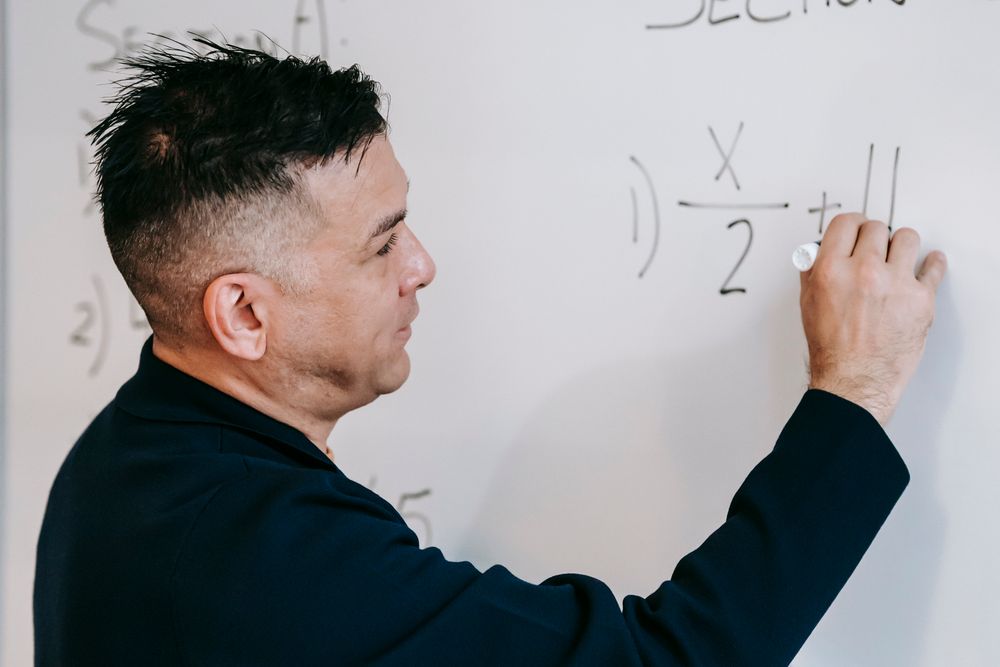 A counsellor explaining requirements at a whiteboard