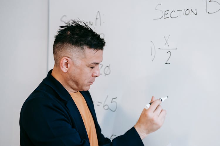 Photo Of Man Teaching On White Board