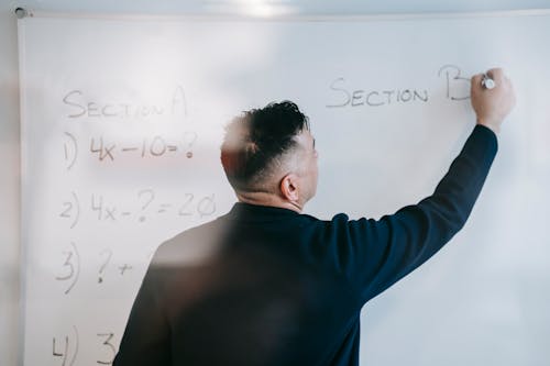 Photo Of Man Writing On Whiteboard