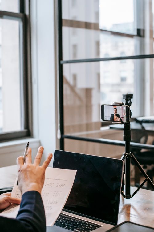 Free A person conducting an online education session using a laptop and smartphone. Stock Photo