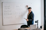 Photo Of Man Teaching On White Board
