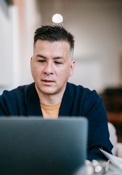 A professional adult working remotely on a laptop in a cozy home office setting.