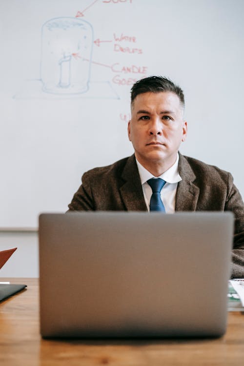 Photo Of Man Sitting In Front Of Gray Laptop