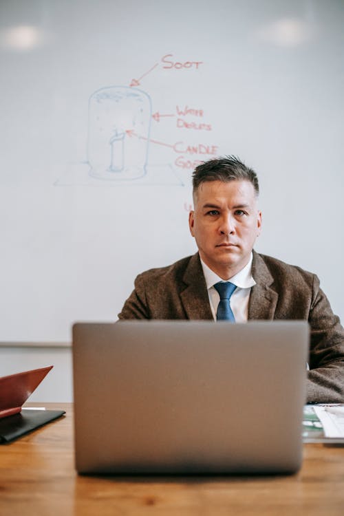 Photo Of Man Sitting In Front Of Grey Laptop