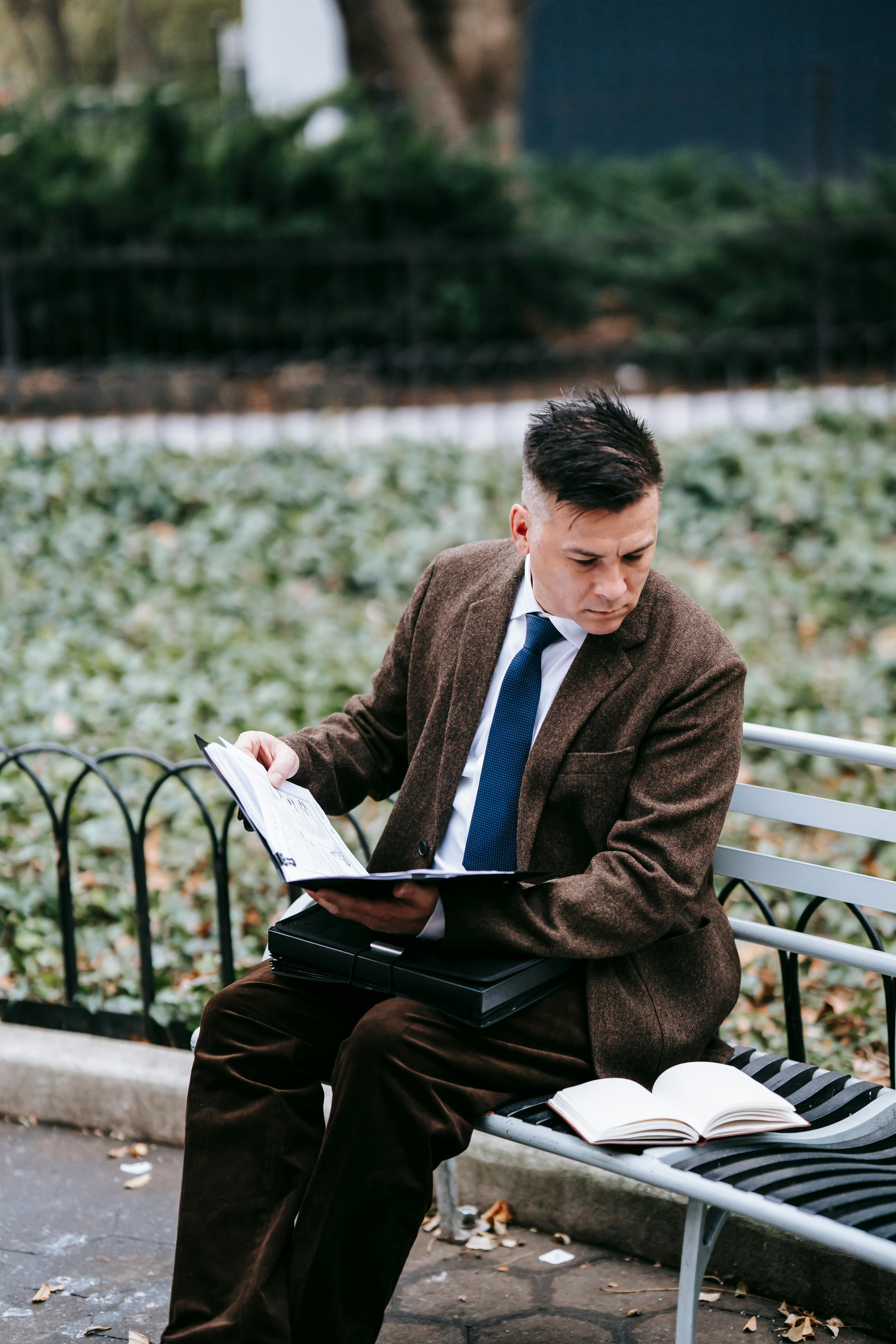 photo of man holding a book while looking on another