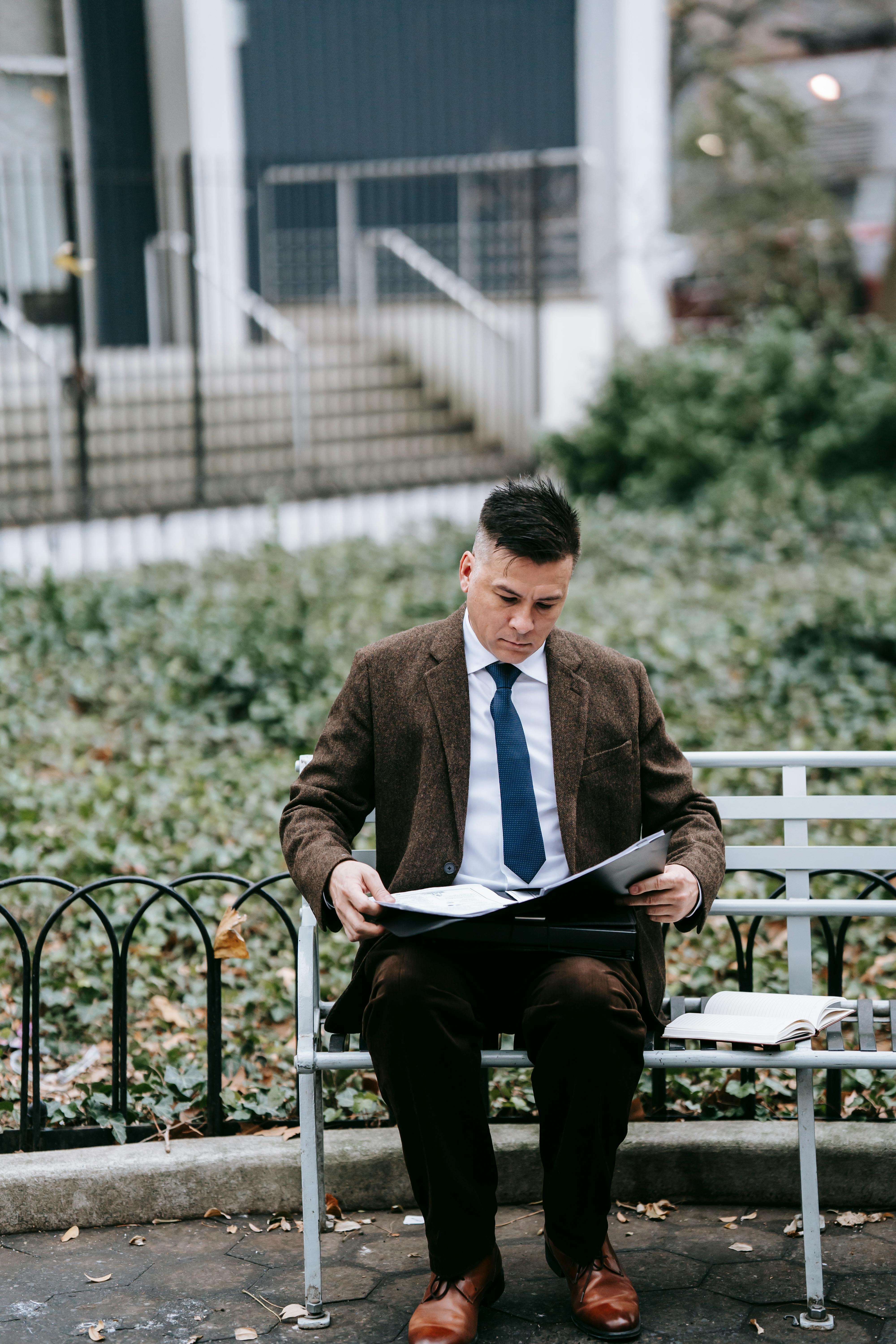 photo of man sitting on metal bench