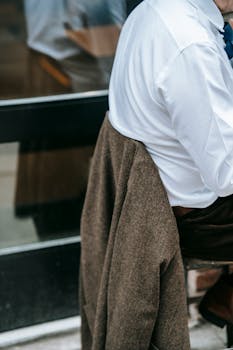 Close-up view of a person in professional attire sitting outdoors, reflecting modern urban life.