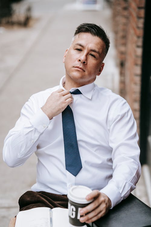 Photo Of Man Fixing His Blue Necktie