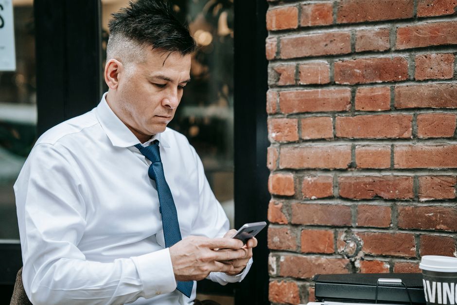 Cliente en terraza española revisando carta digital en móvil