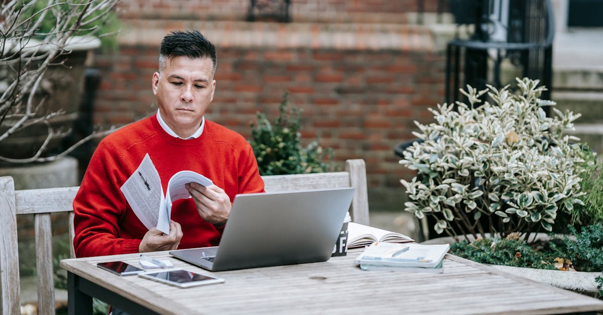A person comparing information on a laptop with written notes