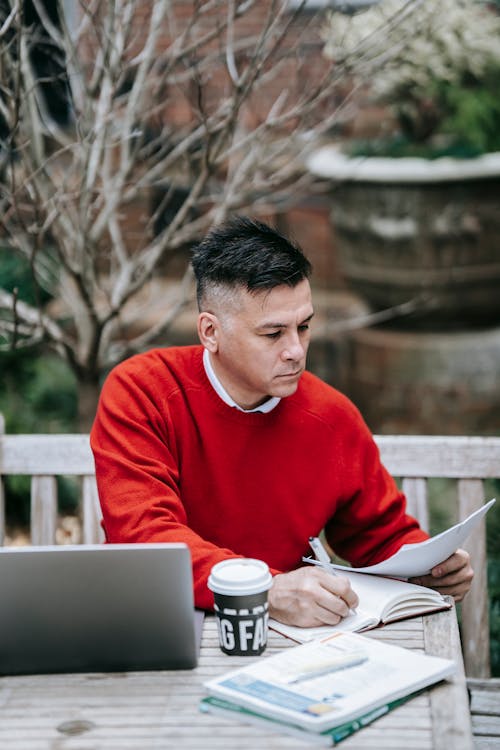 Photo Of Man Writing On Notebook 