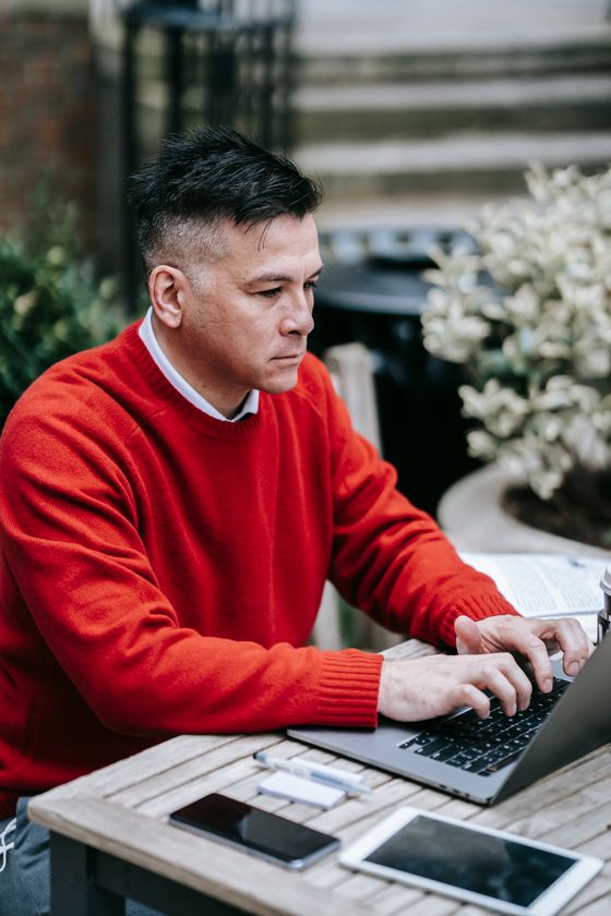 A man working on a laptop at an outdoor table — photo by Vanessa Garcia on Pexels