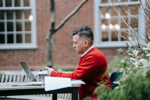 Man In Rood Pak Aan Tafel Zitten