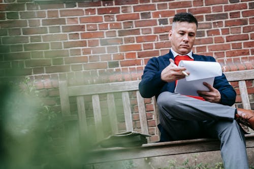 Photo Of Man Sitting On Wooden Bench