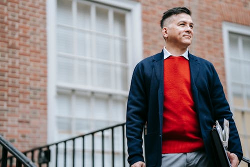 Hombre Con Chaqueta De Traje Negro Y Camisa Roja De Pie Cerca De La Valla De Metal Negro