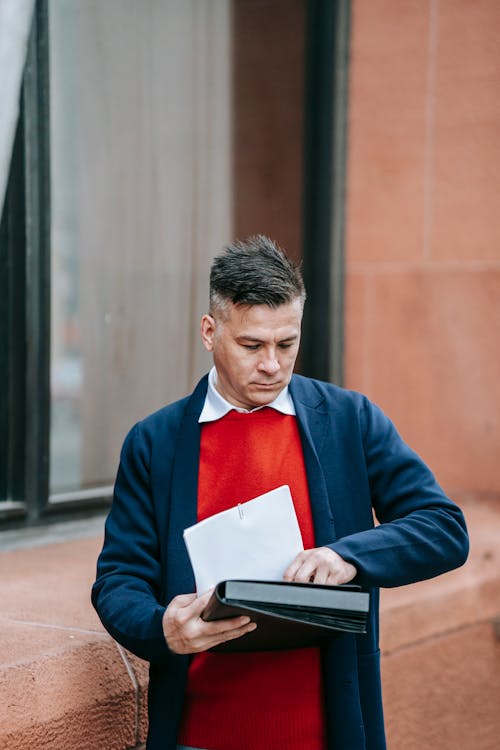 Photo Of Man Reading On Paper