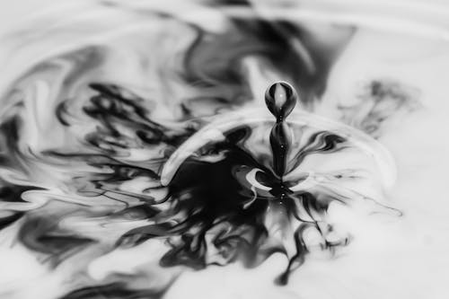 液体に落ちる水のグレースケール写真
