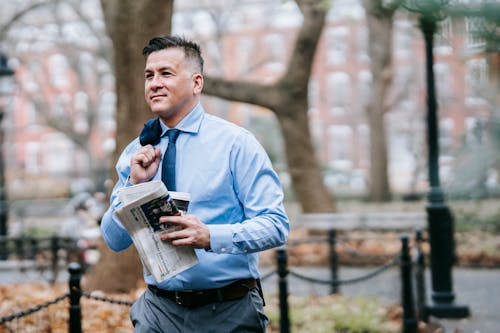 Photo Of Man Carrying Newspaper And Drink