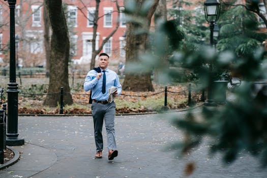 Photo by Vanessa Garcia A stylish man in professional attire confidently walks through a serene urban park.