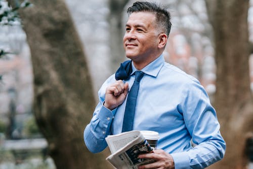 Photo Of Man Carrying Newspaper And Drink