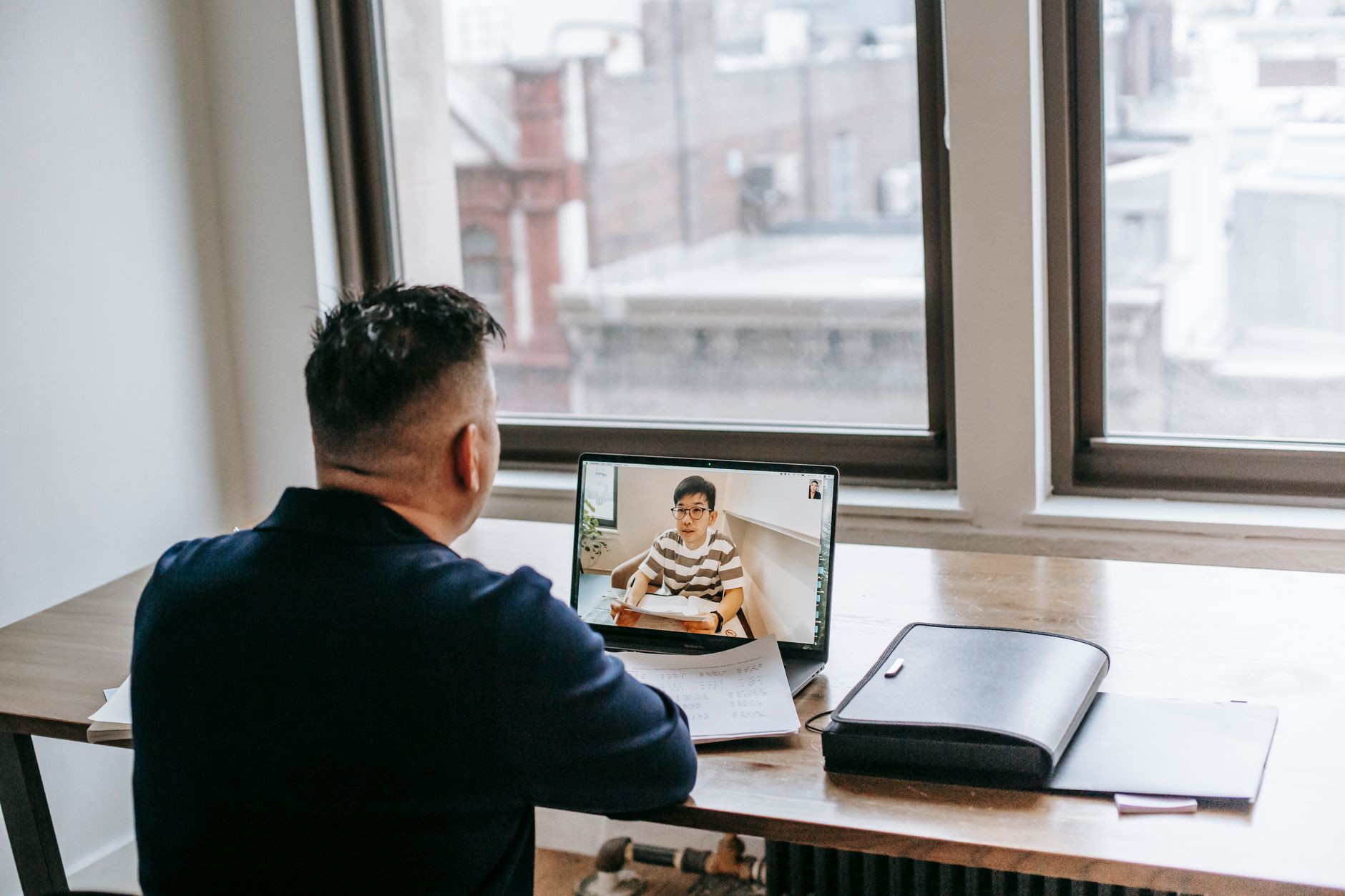 Professional video chatting with a student from a home workspace