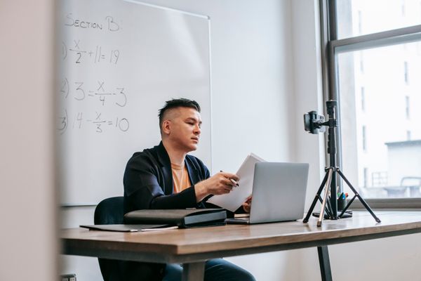 Guru memakai laptop dengan bantuan AI untuk menyiapkan pembelajaran