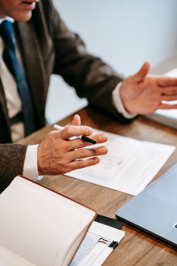Professional reviewing documents at a table, photo by Vanessa Garcia on Pexels