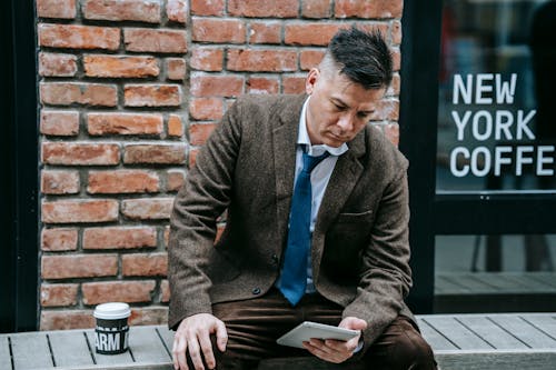 Photo Of Man Sitting On Wooden Surface