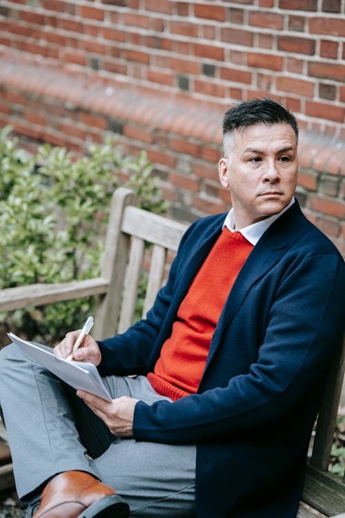 Photo Of Man Sitting On A Wooden Bench 