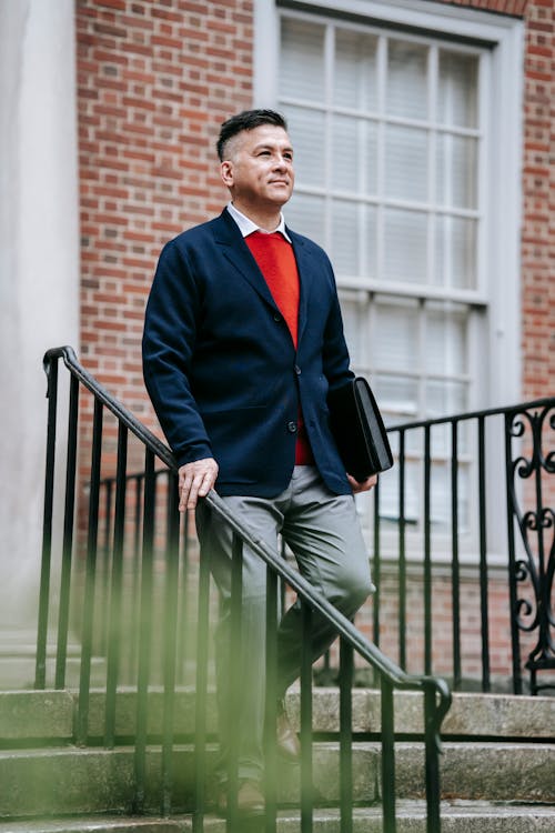 Homme En Blazer Bleu Et Pantalon Gris Debout Sur Un Escalier En Bois Vert