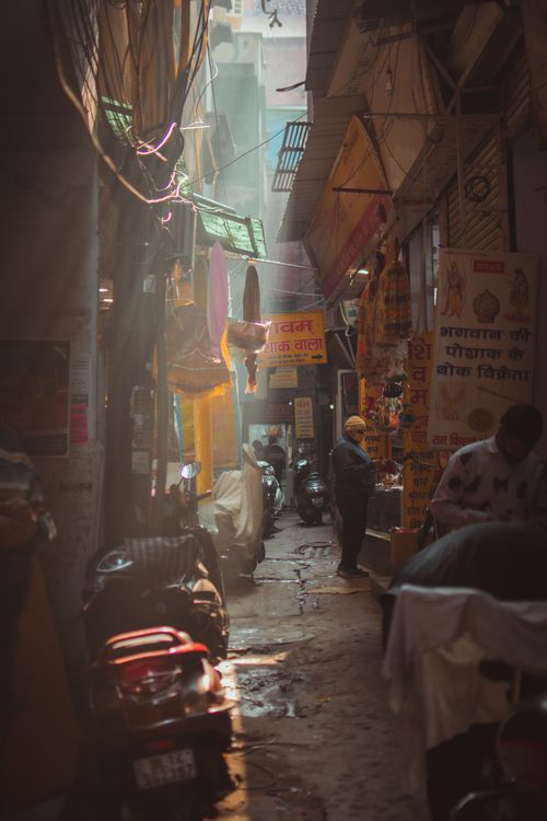 Free Explore the vibrant narrow street market in New Delhi filled with people, motorcycles, and traditional shops. Stock Photo