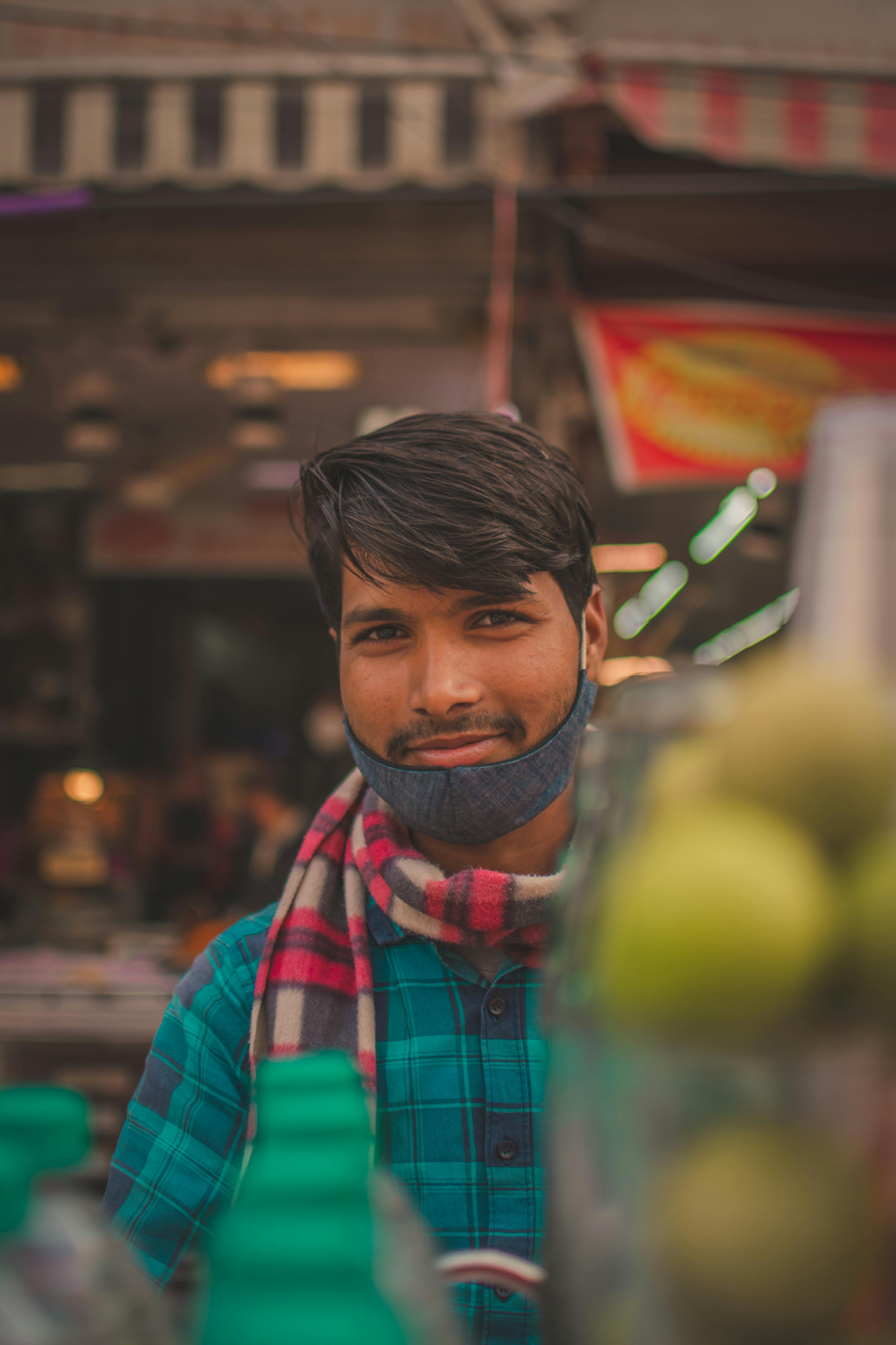 smiling man with face mask on his chin