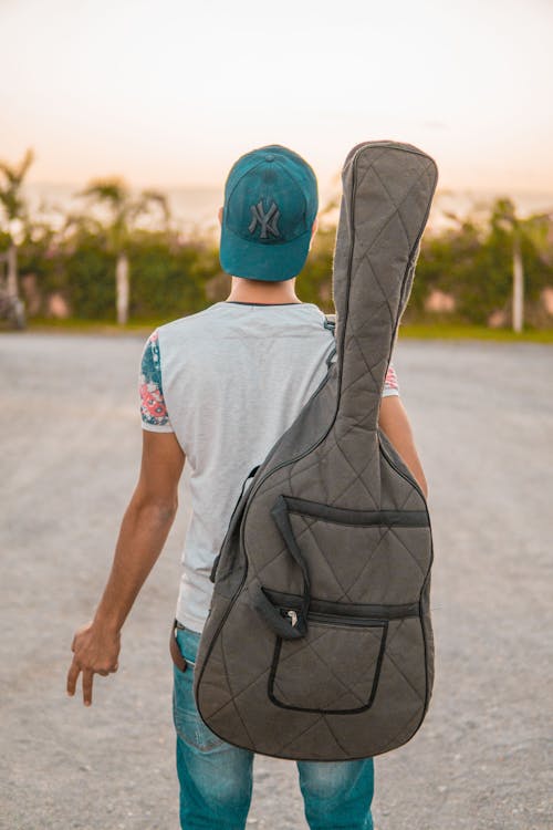 Fotografi Fokus Selektif Man Holding Gig Bag