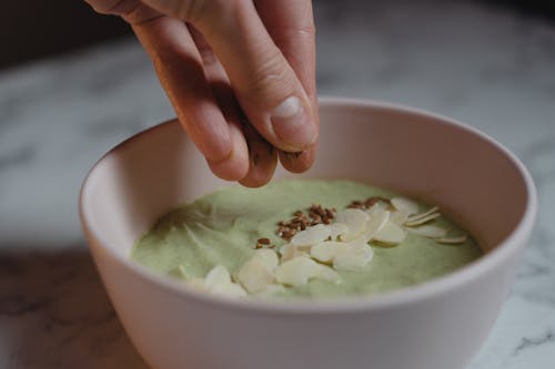 A Person Putting Seeds on a Smoothie Bowl 