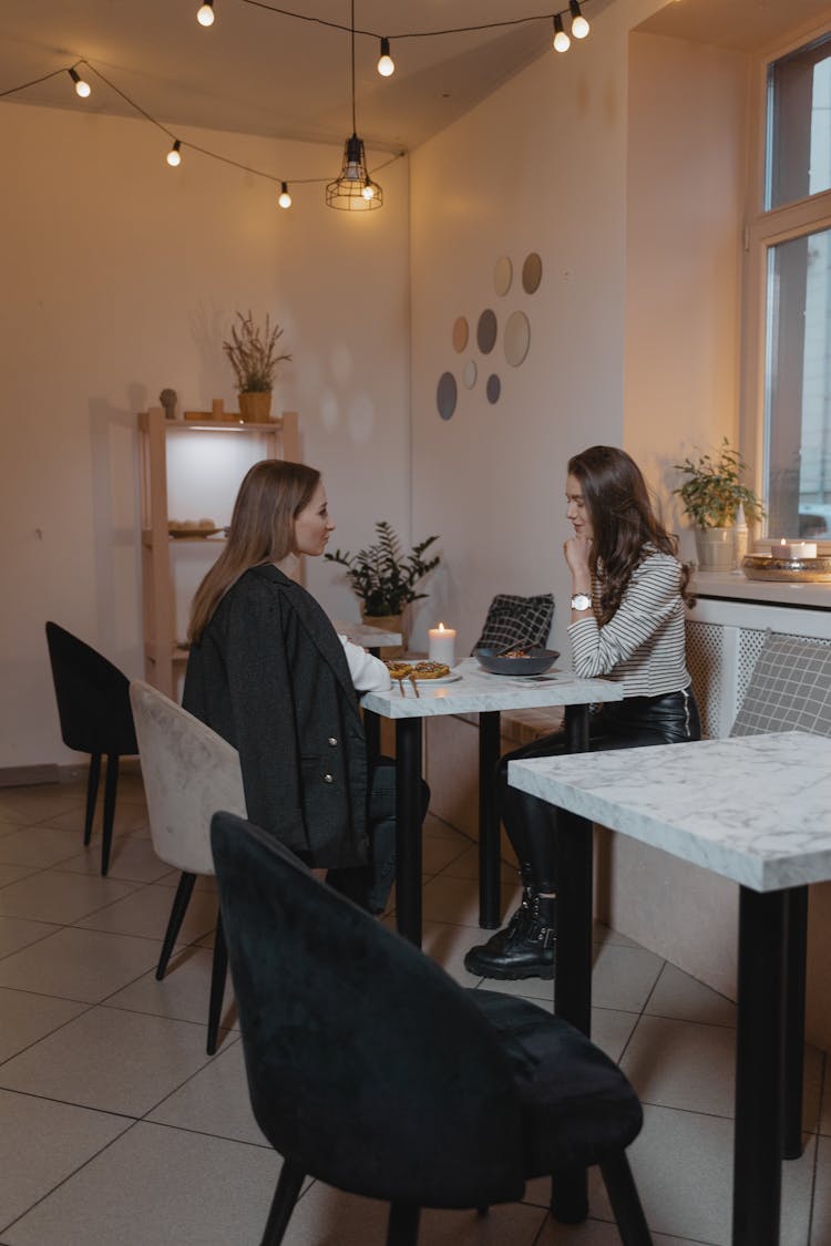 Two Women Sitting At A Table Having Dinner