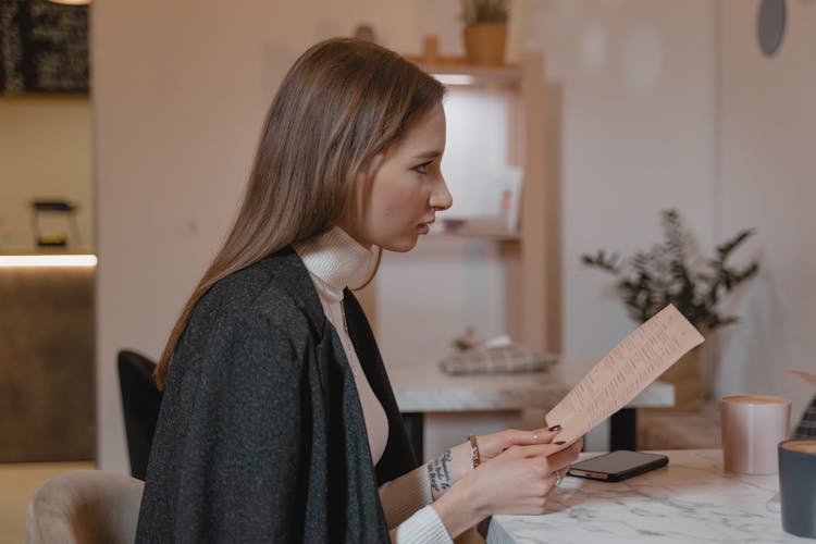 A Woman Holding A Menu 