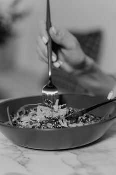 A delicious and healthy salad in a ceramic bowl, captured in grayscale.