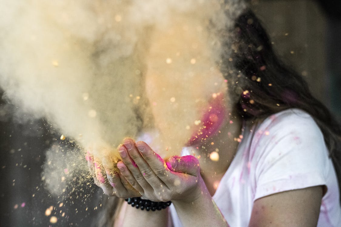 Woman in White Cap-sleeved Shirt Blowing Dust